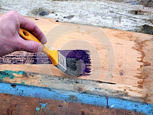 Old brushes in the paint process of painting an old board