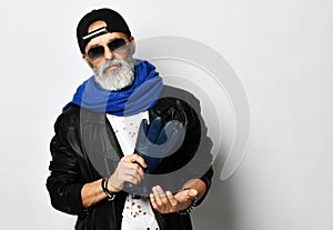 Old brutal senior rich man in leather jacket blue and red baseball cap and long blue scarf stylish fashionable men