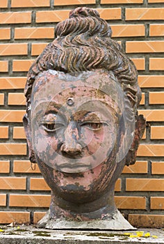 Old Buddha face statue on wall