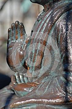 Old Buddhist statue holding coins