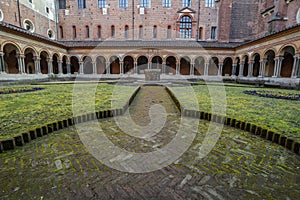 Old building with arches and columns and a beautiful park in front of it