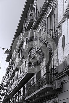 Old building with bars on the balconies sunset and trees around it in black and white