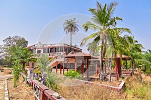 Old building and benches surrounded by pal trees