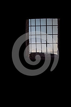 Old building black dark walls with window and rusty bars, vertical background