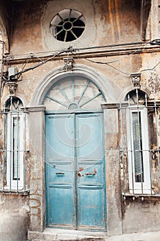 Old building with a blue door and a round window