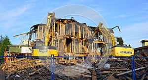 Old building demolition. Excavator working at the construction site.