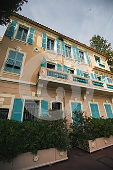 Old building facade, turquoise wooden blinds, open windows, Monaco