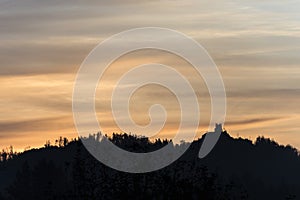 Old building on a forested mountain silhouetted