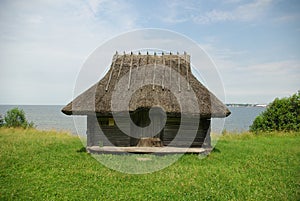 Old building with grass roof by the sea