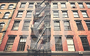Old building with iron fire escape, color toning applied, New York City, USA