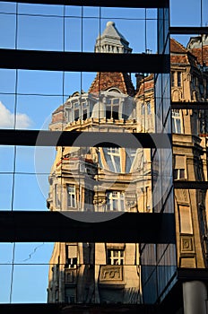 An Old Building On A New Building Reflection.