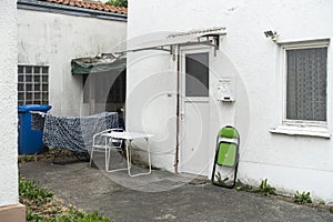 old building patio with waste bin and furniture at the house entrance