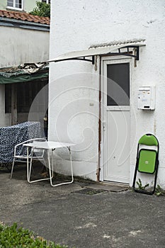 old building patio with waste bin and furniture at the house entrance