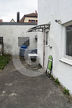 old building patio with waste bin and furniture at the house entrance