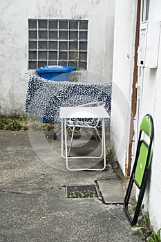 old building patio with waste bin and furniture at the house entrance