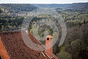 Old building with a red brick chimney and a tiled roof