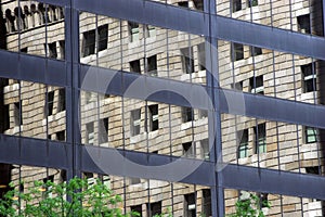 Old building reflected in windows of modern office