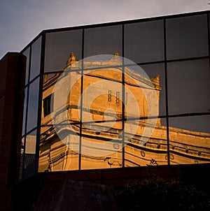 Old building reflecting in a new building