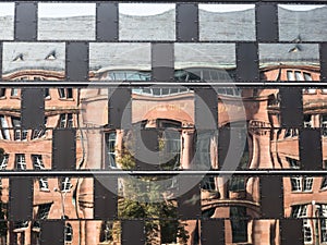 Old building reflecting in the windows of a modern building