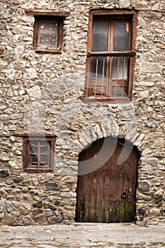 Old building rocks and stones maded. Wooden door and windows crooked