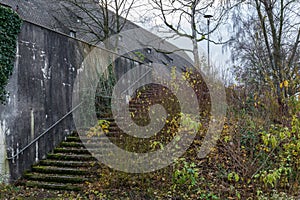 Old building ruins with stone column archway and overgrown stone stairway