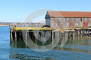 An old building on a run down pier in a bay