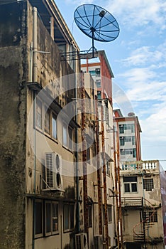 Old building with satellite against blue sky