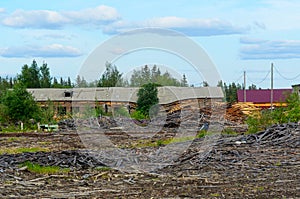 An old building with a strangely sagging roof near an abandoned sawmill field in a village