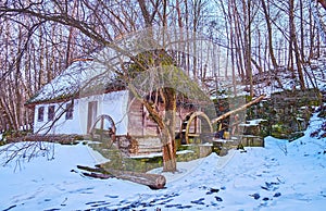 The old building of water mill at the snowy hill, Bukovyna Region, Pyrohiv Skansen, Kyiv, Ukraine photo