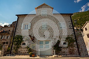 old building with white wooden windows and doors in city of Perast