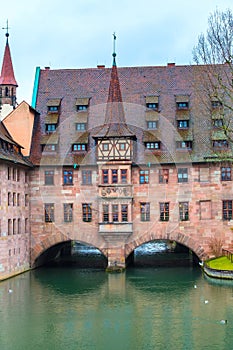 Old buildings and arch bridge reflected in water. Nuremberg, Bavaria