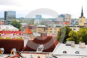 Old buildings with bright roofs in the foreground and morden buildings on the background in Tallinn