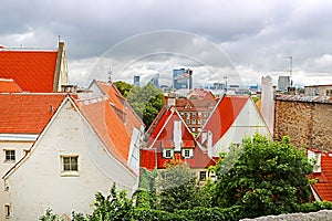 Old buildings with bright roofs in the foreground and morden buildings on the background in Tallinn, Estonia