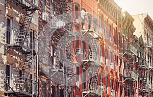 Old buildings with fire escapes in New York City, color toning applied, USA