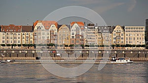 Old buildings near the river in Europe, ships are sailing