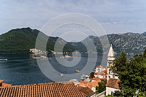 Old buildings in Perast town, Bay of Kotor, Montenegro with forested mountains in the background