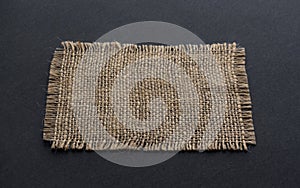 Old burlap fabric napkin on black background