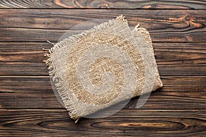 Old burlap fabric napkin, sackcloth on table background. top view with copy space