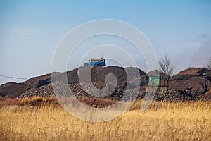 Old bus on slagheap in the field with blue sky