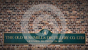 The Old Bushmills Distillery Co. Ltd Licensed to distil in 1608 sign on rustic brick wall