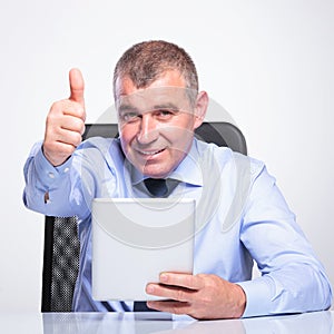 Old business man with pad shows thumb up