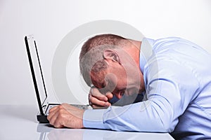 Old business man sleeping on his laptop