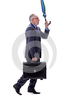 Old businessman with an umbrella and luggage isolated on white