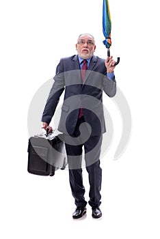 Old businessman with an umbrella and luggage isolated on white