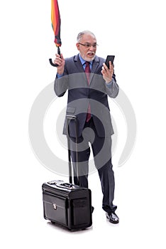 Old businessman with an umbrella and luggage isolated on white