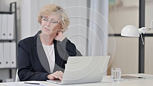Old Businesswoman having Neck Pain while Working on Laptop