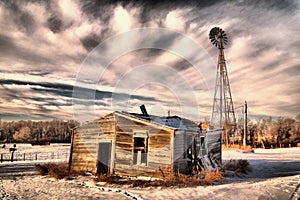 Old cabin and windmill in the winter