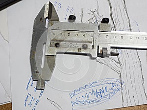 Old caliper and Micrometer on technical drawings