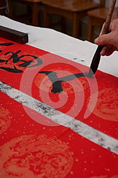An old calligrapher writes couplets during the Chinese Year of the Dragon.