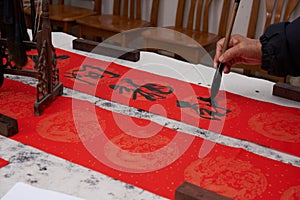 An old calligrapher writes couplets during the Chinese Year of the Dragon.